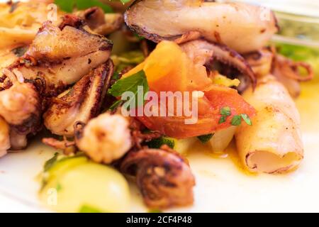 Leckere gegrillte Tintenfische mit Gemüse auf dem Teller Stockfoto