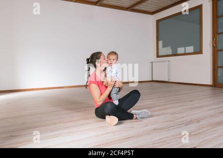 Frau hält Baby im Fitnessstudio Stockfoto
