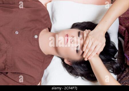 Asiatische Masseur tun thai Kopf massage für kaukasische Frau in Spa-Salon Stockfoto