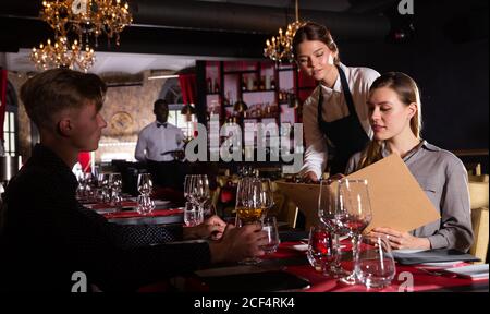 Freundlich lächelnd weibliche Kellner bringen um Besucher im luxuriösen Restaurant Stockfoto