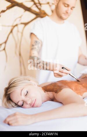 Schöne junge Mädchen mit kosmetischen Maske im Spa-Salon Stockfoto