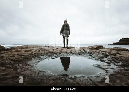 Weibchen steht auf einer Klippe und kontempliert Stockfoto