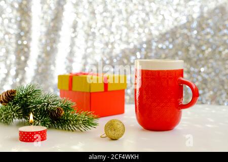 Bild von einem schönen Weihnachtstisch Einstellung, hält eine weibliche Hand mit roter Maniküre eine Tasse. Silvesterparty, Heiligabend Stockfoto