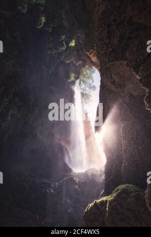 Blick von innen auf die wilde Höhle mit strahlenden Strahl Sonnenlicht gegen Eintritt Stockfoto