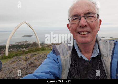 Mann, der SELPHY an der Spitze von North Berwick Law nimmt Stockfoto