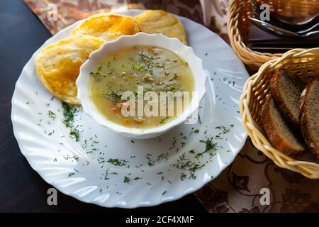 Typisch belarussisches Gericht Machanka, Sauce mit geschmortem Fleisch, Gemüse, Pilzen und saurer Sahne, serviert mit Pfannkuchen Stockfoto