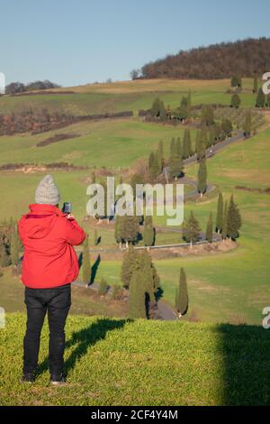 Rückansicht des Reisenden Mannes, der schöne grüne Landschaft in der Toskana, Italien fotografiert Stockfoto