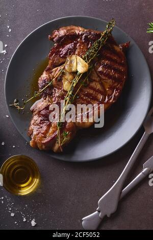 Gegartes Ribeye Black angus Prime Beef Steak mit Butter, Meersalz, Kräutern und Knoblauchscheiben. Stockfoto
