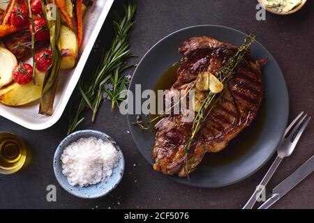 Gegartes Ribeye Black angus Prime Beef Steak mit Kräutern, Meersalz und gegrilltem Gemüse. Stockfoto