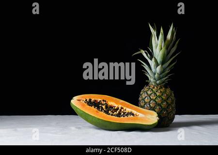 Stillleben mit Ananas und geschnittener Papaya Stockfoto