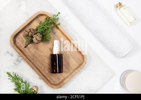 Draufsicht Zypresse ätherisches Öl auf einem Marmortisch Holztablett Stockfoto