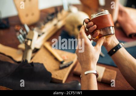 kaukasische Leder Handwerk Schnurrbart Mann trägt Tasse arbeiten als Handwerker In seiner Werkstatt Stockfoto