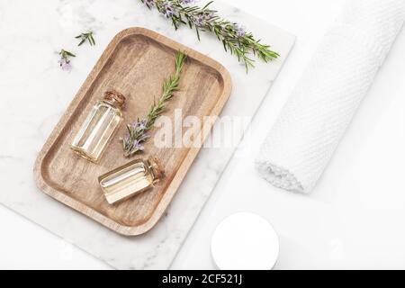 Rosmarin ätherisches Öl in Glasflasche auf Holztablett. Salvia Rosmarinusöl Stockfoto