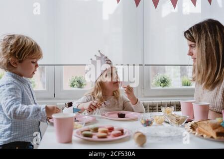 Frau teilt süße Schokolade Dessert mit Flagge auf rosa Teller Mit Kindern zu Hause Stockfoto