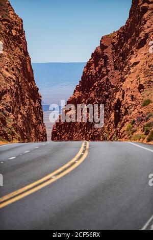 Leerer landschaftlicher Highway in Arizona, USA. Straße in den Bergen. Eine lange gerade Straße, die zu einem felsigen Berg führt. Stockfoto