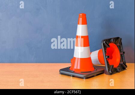 Zwei Straßenkegel auf dem Holztisch. 3D-Rendering Stockfoto