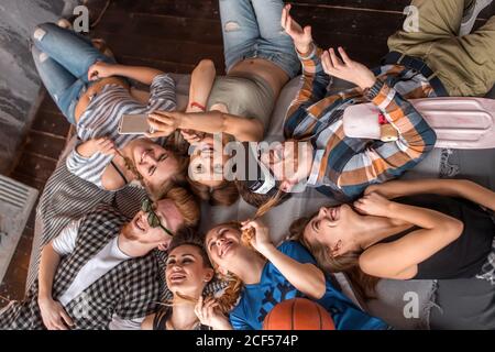 Gruppe von Freunden, die Spaß zu Hause Skifahren mit Viewer für virtuelle Realität Stockfoto