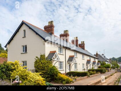 Eine Reihe von hübschen Hütten am Straßenrand in Otterton, einem malerischen kleinen Dorf im Otter Valley in East Devon, Südwestengland Stockfoto