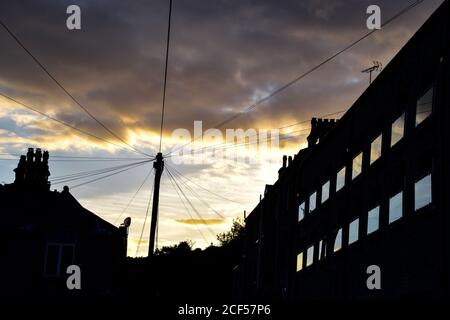 Der Sonnenuntergang spiegelt sich in den Fenstern der renovierten Mühle an der Brunswick Street, Hebden Bridge, Pennines, Yorkshire Stockfoto