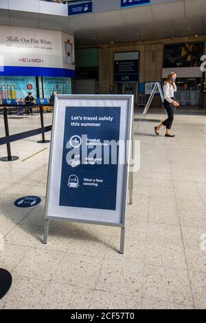 Hinweis mit Covid-19 Anleitung auf der Bahnhofsanlage von Waterloo Station, London: Reisen Sie in ruhigeren Zeiten, waschen Sie Ihre Hände, tragen Sie eine Gesichtsbedeckung Stockfoto