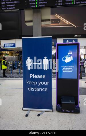 Hinweis auf der Bahnhofsanlage von Waterloo Station, London, die Menschen zurückhält, um Abstand zu halten und Handdesinfektionsmittel zu tragen und ihre Hände zu waschen Stockfoto