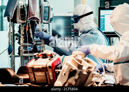 Gruppe von professionellen Ärzten in Schutzuniform im Krankenwagen stehen Auto mit Ausrüstung und Vorbereitung für den Patiententransport Stockfoto