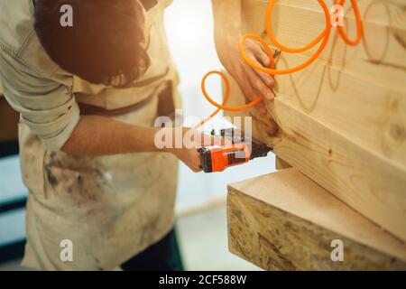 Carpenter brad mit Nagelpistole, um Tür Rahmung trimmen, mit dem Warnschild, dass alle Elektrowerkzeuge haben auf ihnen gezeigt, die Sicherheit concep veranschaulichen Stockfoto