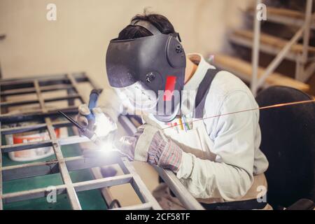 Männliche in Gesichtsmaske Schweißnähte mit Argon - Lichtbogenschweißen Stockfoto