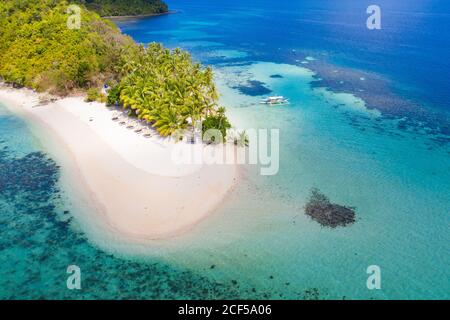 Luftaufnahme der Boote neben einer kleinen grünen tropischen Insel das azurblaue Wasser des Ozeans Stockfoto