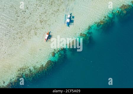 Von oben Drohnenansicht der Boote in Ruhe auf seichtem Von sandiger Küste Stockfoto