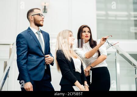 Zwei Geschäftsfrau und Geschäftsmann posieren im Büro Stockfoto