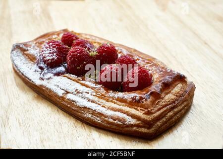 Von oben lecker hausgemachtes Blätterteig mit frischen Erdbeeren Und Zuckerpulver auf Holztisch gelegt Stockfoto