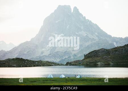 Nebliger Morgen in majestätischen Pyrenäen Berge mit Reisenden Zelte in der Nähe Klarer See Stockfoto