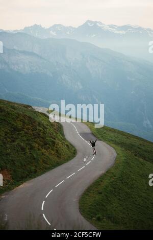 Landschaftlich schöne Aussicht auf die Berge und man Skateboarding auf der Straße Stockfoto