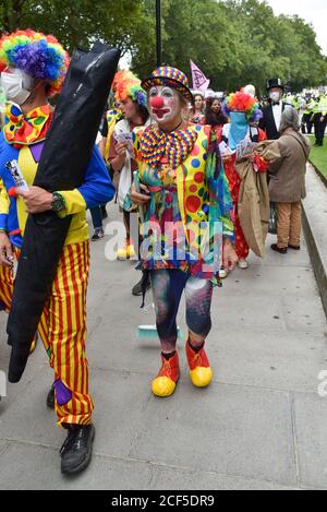 Demonstranten, die während der Demonstration als Clowns gekleidet waren.vor den HM-Finanzgebäuden marschierten die Demonstranten beim Extinction Rebellion Carnival of Corruption in Richtung Buckingham Palace, wurden aber von der Polizei in der Mall blockiert. Aktivisten fordern, dass die Machtenden in Klima- und Umweltfragen aktiv werden. Stockfoto