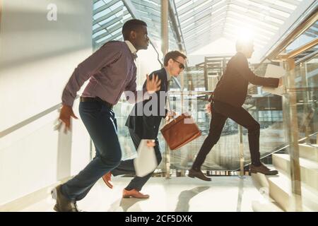 Lebhafte Geschäftsleute, die auf Treppen laufen. Konzept von Teamarbeit, Zweisamkeit oder Business-Wettbewerb und Rennen. Stockfoto