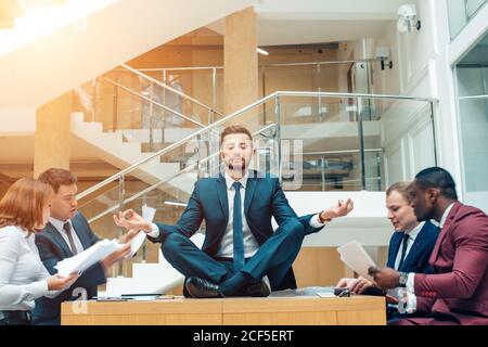 Geschäftsverhandlungen, männliche Partner streiten, lustig unbeschwerten Mann ruhig in Stress-Situation, meditieren mit komponierten Lächeln, Umgang mit emo Stockfoto