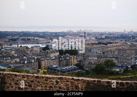 Von oben der Küstenstadt mit braunen Häusern und grün Bäume am Nachmittag mit Horizont Linie und Berge weit weg Stockfoto