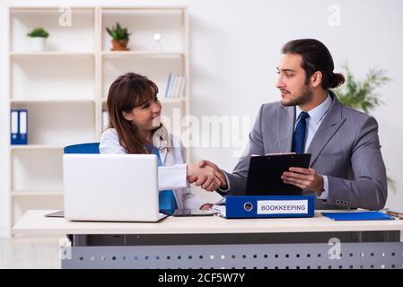 Junger Arzt und kranker Geschäftsmann im Büro Stockfoto