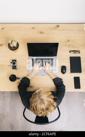 Draufsicht auf die Frau am Holzschreibtisch mit Laptop, Notebook, Handy-Notebook und Fotokamera. Stockfoto