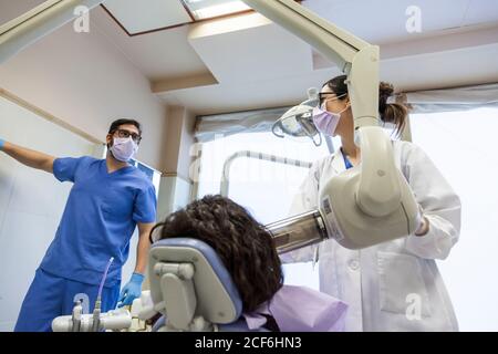 Zahnarzt und sein Assistent nehmen eine Röntgenaufnahme des Patienten Gebiss Stockfoto