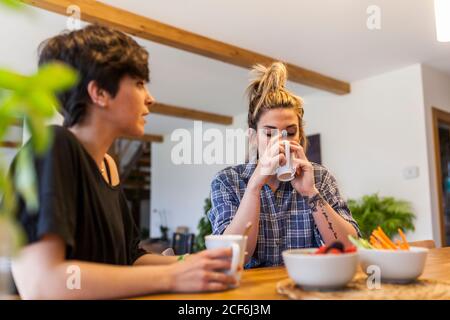 Zwei schöne und junge Frauen beim Frühstück zu Hause und Spaß haben Stockfoto