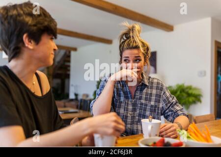 Zwei schöne und junge Frauen beim Frühstück zu Hause und Spaß haben Stockfoto