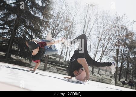 Seitenansicht von jungen Jungs üben Pause Tanz auf kariert Boden im Park bei sonnigem Wetter Stockfoto