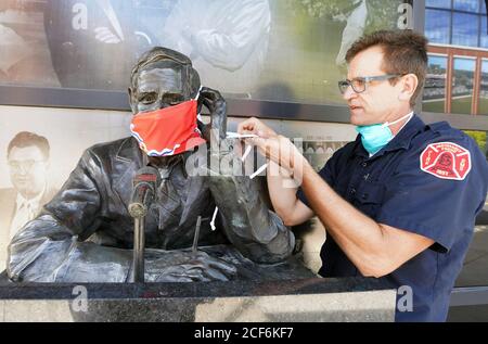 St. Louis, Usa. September 2020. St. Louis Feuerwehrmann Neil Benda passt die St. Louis Flagge Maske, die er auf der Statue von Jack Buck, außerhalb des Busch-Stadium, in St. Louis am Donnerstag, 3. September 2020. Die Feuerwehr unterstützt die St. Louis Arts Chamber of Commerce, indem sie Gesichtsbedeckungen an einer Reihe von Statuen in der Gegend von St. Louis installiert und die Botschaft dazu drängt, Masken zu tragen, um die Ausbreitung von Covid zu stoppen. Foto von Bill Greenblatt/UPI Kredit: UPI/Alamy Live News Stockfoto