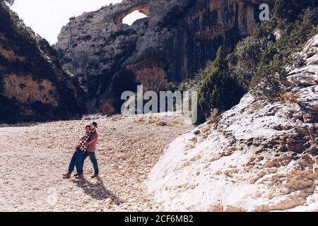 Junges Paar umarmt in Canyon zwischen Felsen Berge in sonnig Tag Stockfoto