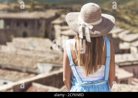 Frau im Hut ruht auf der Straße mit landschaftlich schöner Aussicht Stockfoto