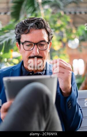 Alter schöner Mann mit digitalen Tablet im Freien Stockfoto