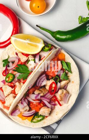 Hausgemachte mexikanische Tacos mit frischem Gemüse und Huhn auf weißem Hintergrund. Gesundes Essen .Burritos. Stockfoto