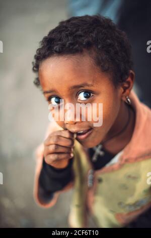 Lalibela, Äthiopien - 04. November 2018: Von oben ein kleines Mädchen, das mit Interesse an der Kamera schaut, Lalibela, Äthiopien Stockfoto